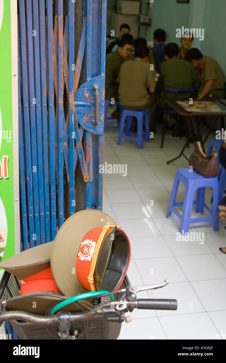 Vietnamesische Soldaten in einem Restaurant ihrer Armee Uniform Hüte sind außen in ein Fahrrad Korb Hanoi-Vietnam Stockfoto