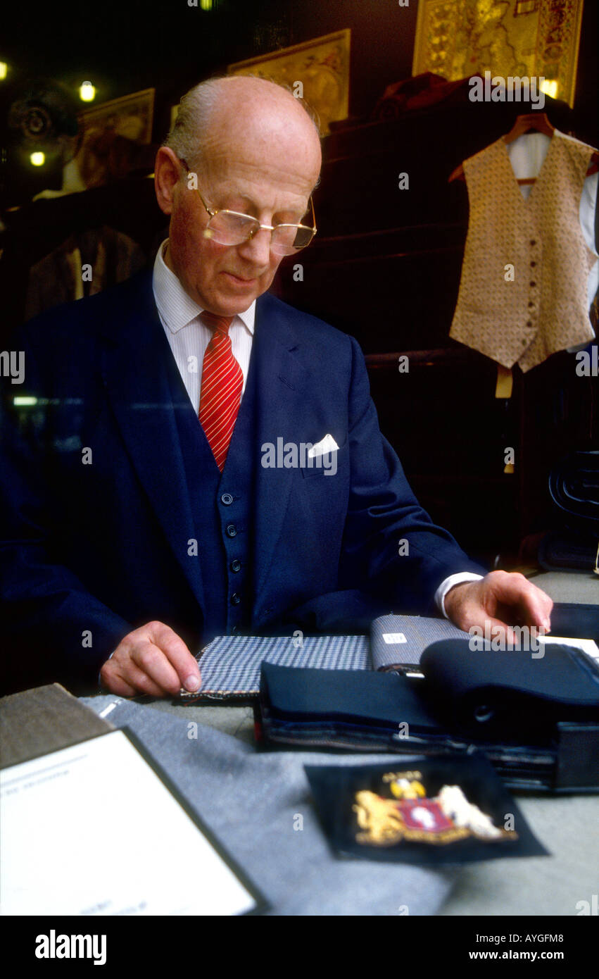 Harry Errington Errington Whyte Meister Schneider kontrollierenden Stoff im Fensterlicht, das Savile Row nach Maß, schneidert London Stockfoto