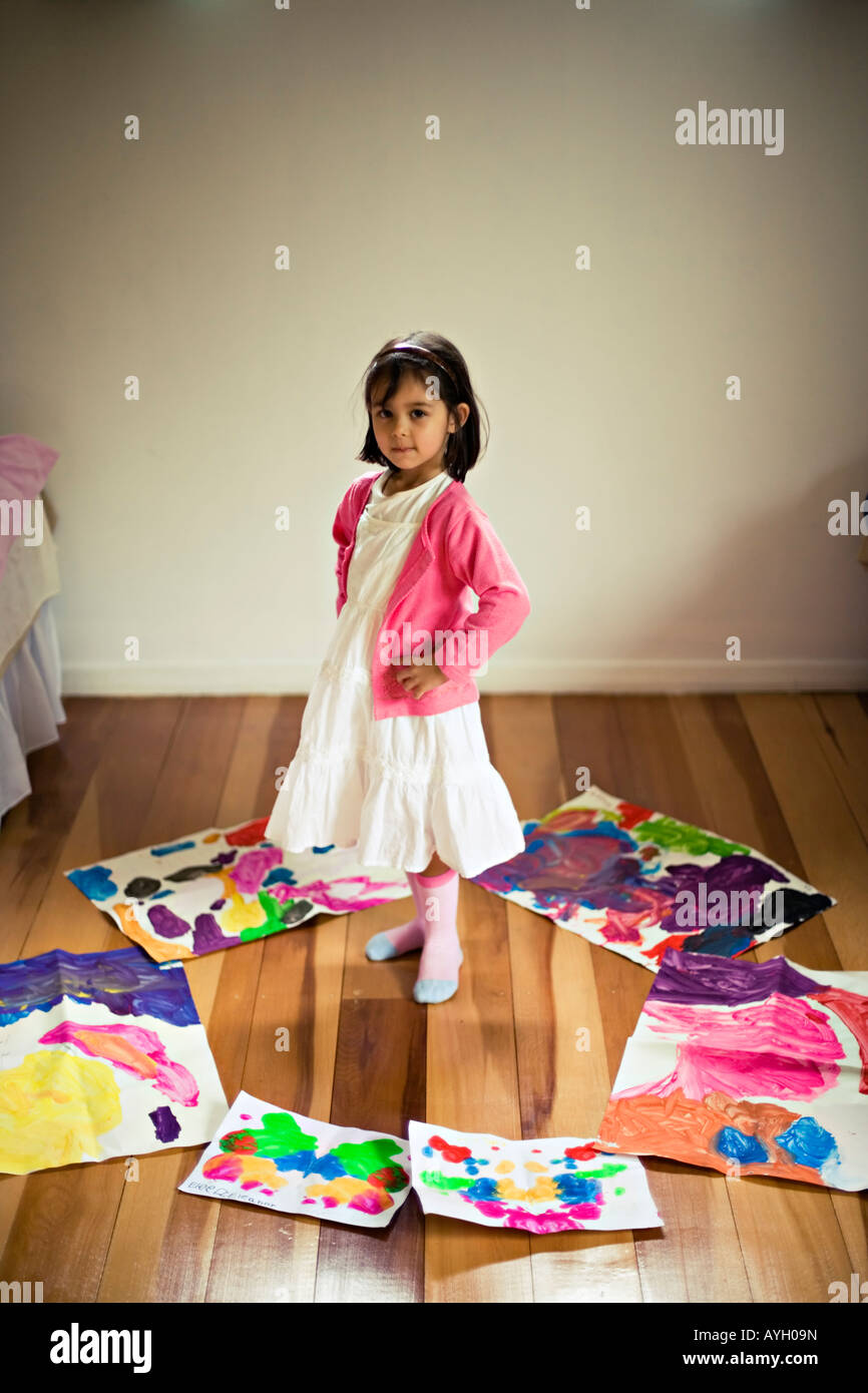 Kleines Mädchen im Alter von vier Jahren steht im Kreis ihrer eigenen künstlerischen Arbeit Stockfoto