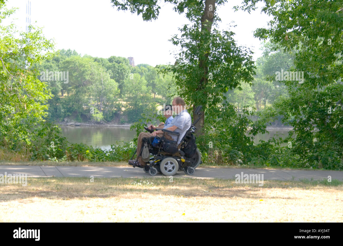 Körperlich behinderte Menschen in Rollstühlen Rollen entlang der West River Parkway durch den Mississippi River. Minneapolis Minnesota USA Stockfoto