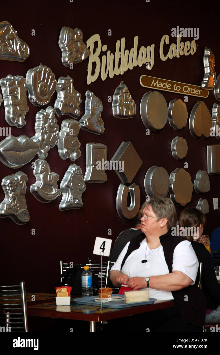 Lady Blick auf Display Backförmchen in einem Café in Wellington Stockfoto