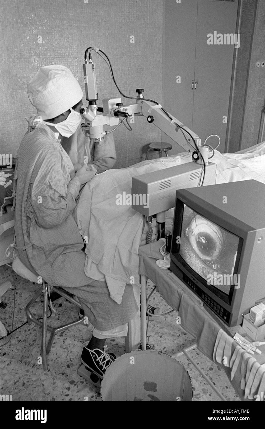 B/W eines Augenchirurgen, der eine Kataraktoperation mit Vergrößerung auf einem Monitor im Asmara-Krankenhaus durchführt. Asmara, Eritrea Stockfoto