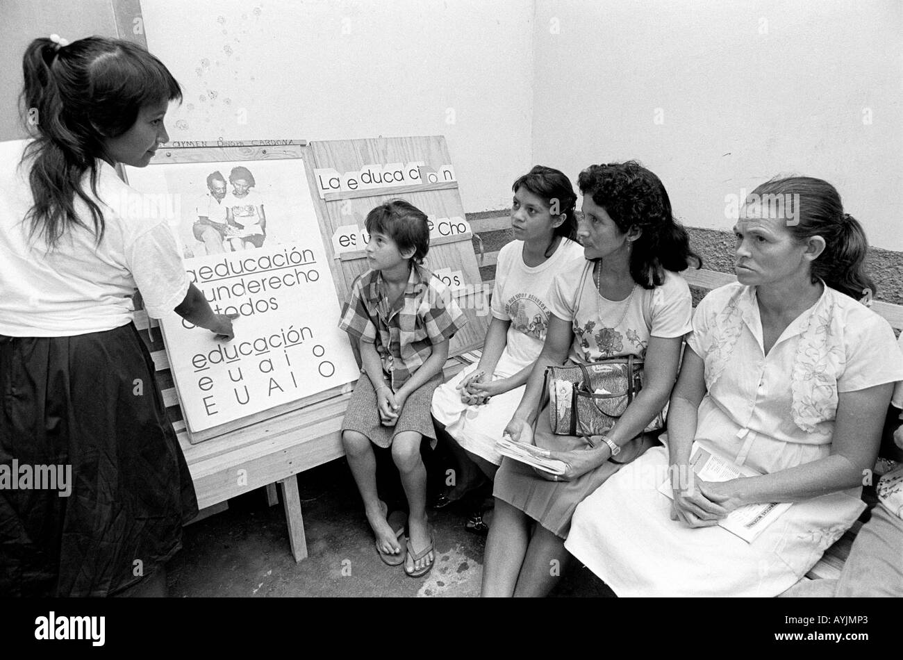 s/w von weiblichen Erwachsenen und Kindern aus einer ländlichen Bauerngemeinschaft, die an einem Alphabetisierungskurs teilnehmen. Honduras Stockfoto