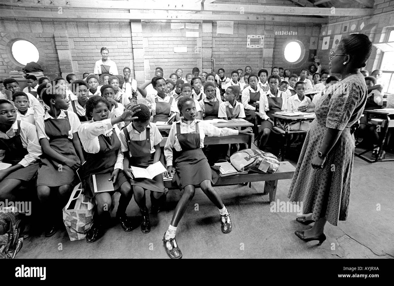 B/W einer Lehrerin mit einem Klassenraum voller Schüler in einer ländlichen afrikanischen Schule. Lesotho Stockfoto