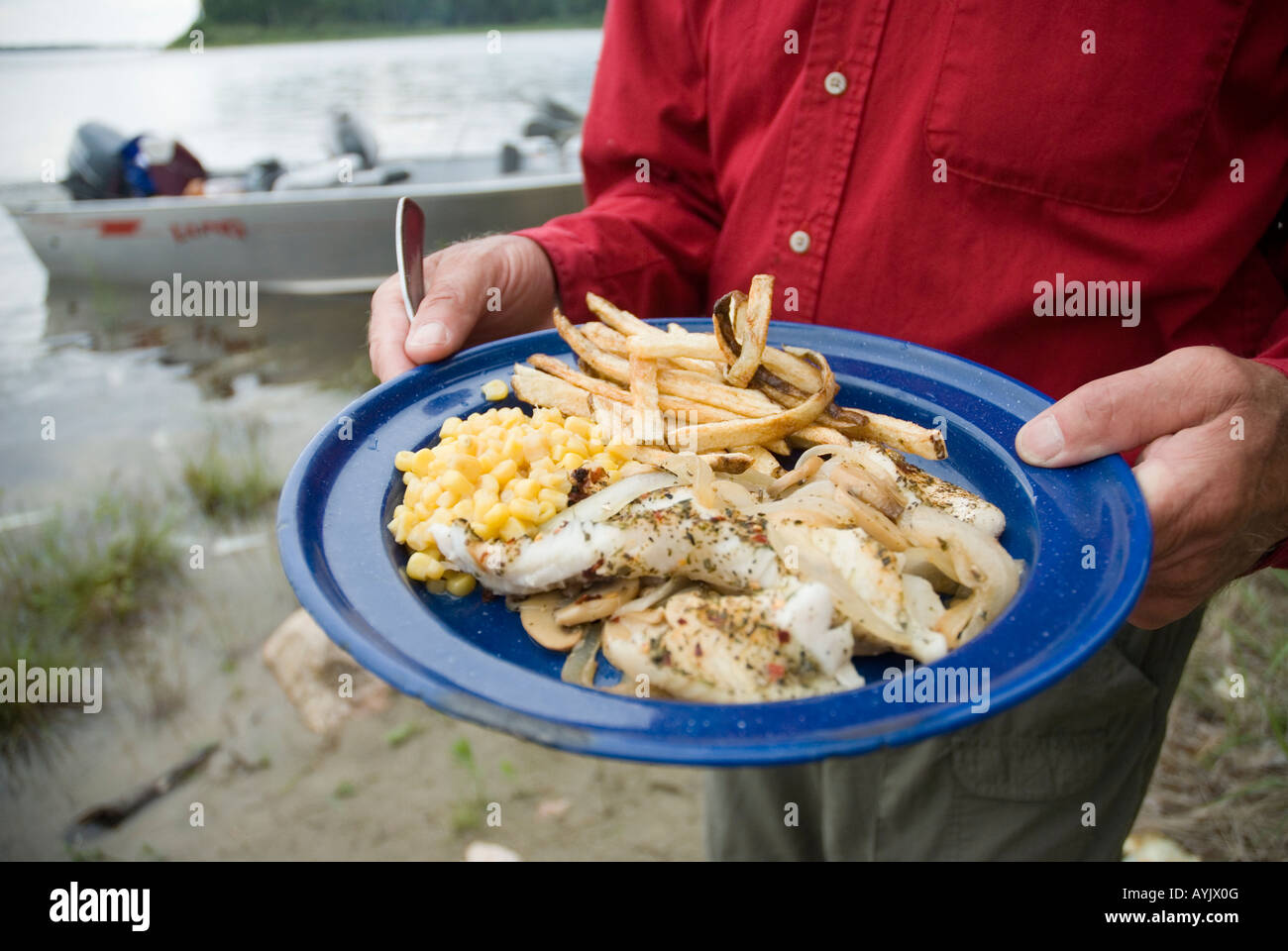 Angler mit Platte mit Fisch Stockfoto