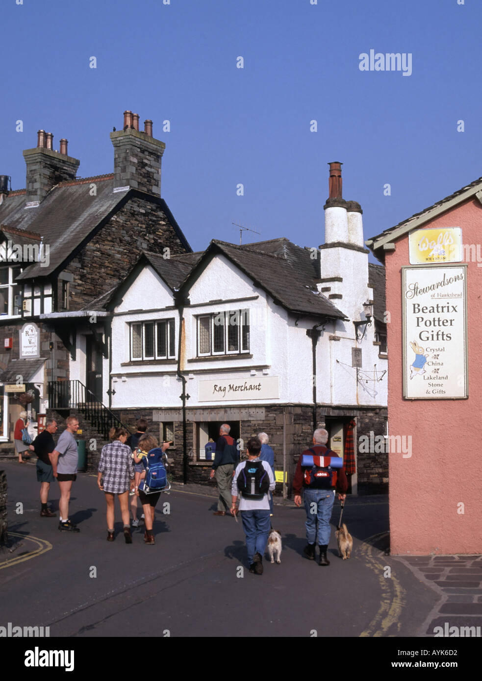 Ambleside Lake District Dorf Hundewiesen Paar & Rucksack Touristen neben Beatrix Potter Gift Shop anmelden Menschen in engen Straße Cumbria England Großbritannien Stockfoto