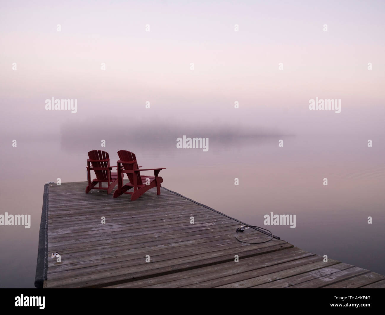 Lake Of The Woods, Ontario, Kanada, zwei rote Adirondack Stühle auf einem dock Stockfoto