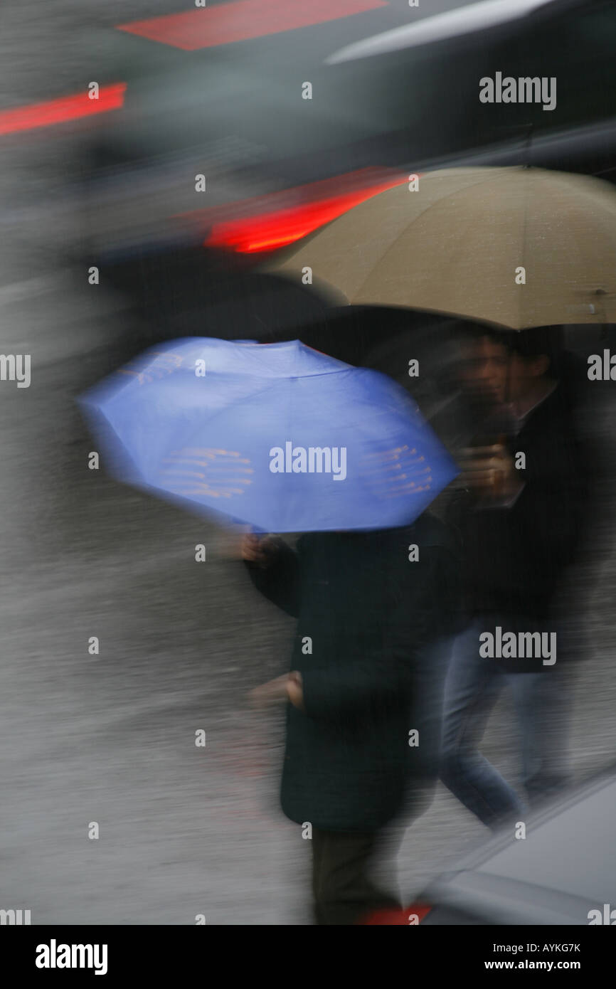 Menschen Kreuzung Straße mit Schirm im Regen Stockfoto