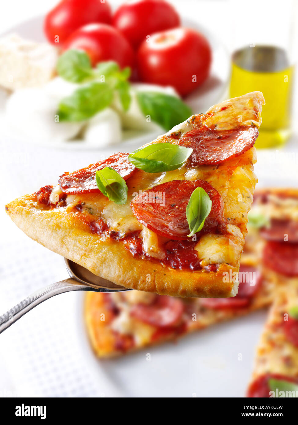 Pizzastück mit Peperoni gekrönt. Stockfoto