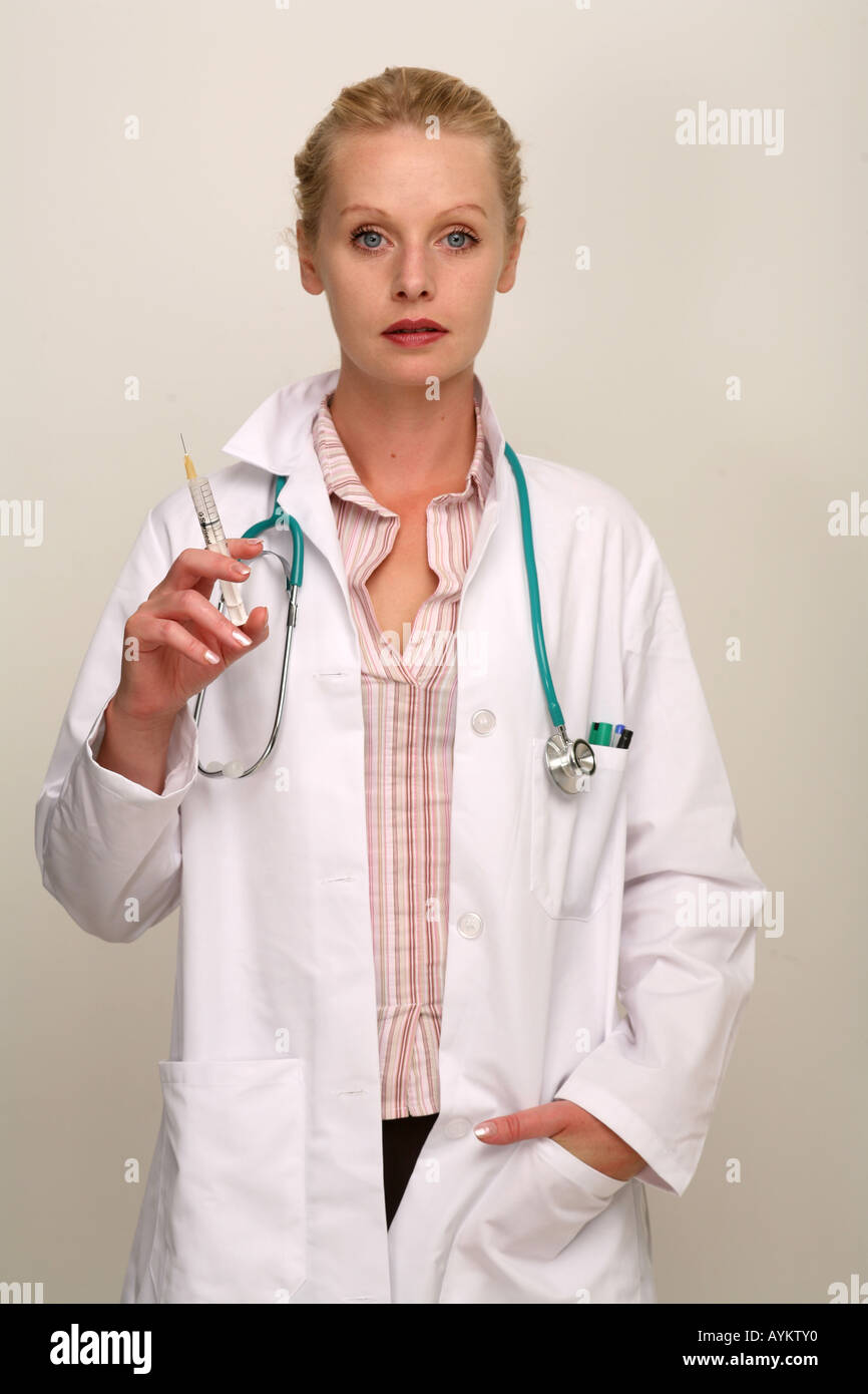 Ärztin im weißen Kittel mit Hand in der Tasche und Spritze. Stockfoto