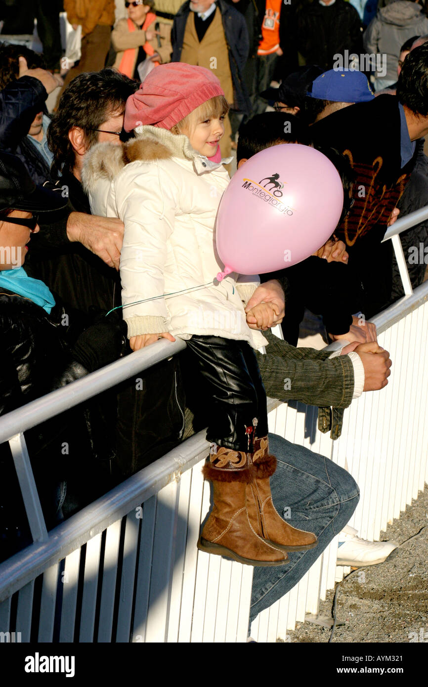 Kleines Kind weiblich sitzend auf einem Fenche statt von ihrem Vater mit einem rosa Ballon Stockfoto