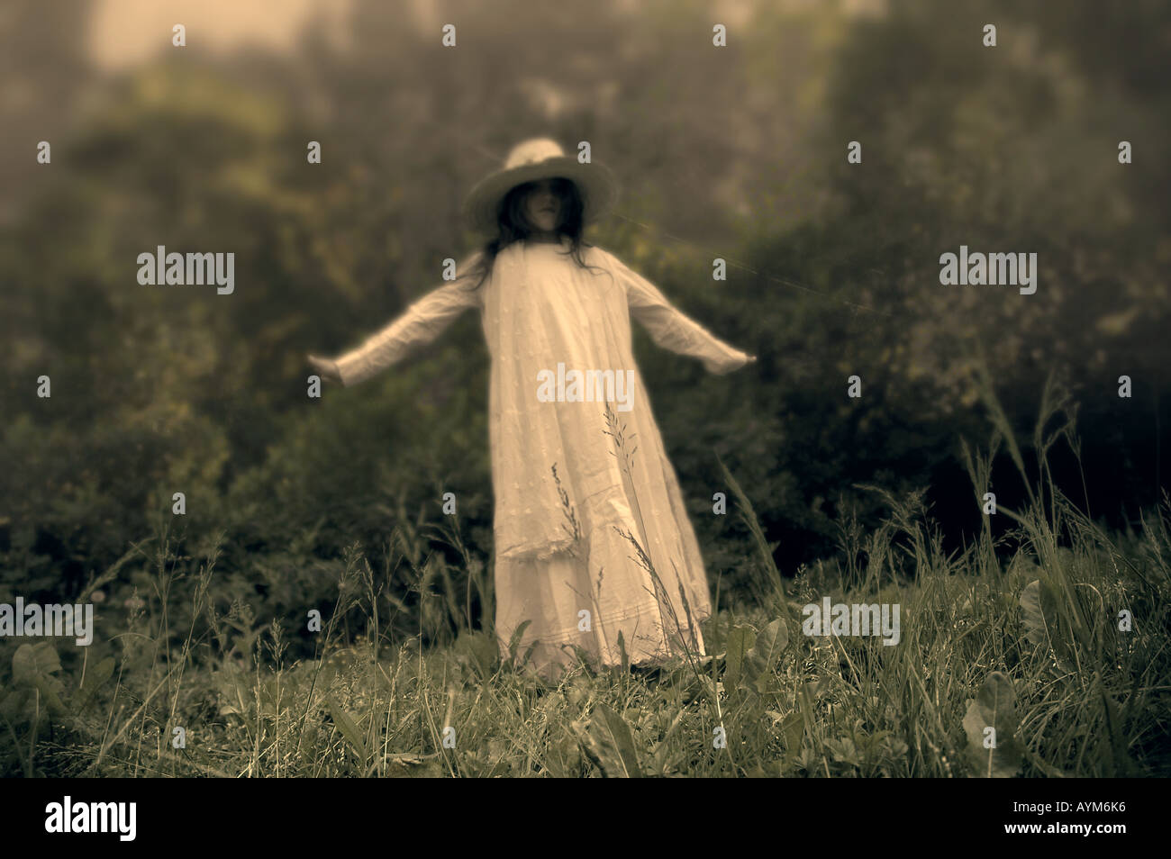 Mädchen im weißen Kleid tanzen im Garten Stockfoto