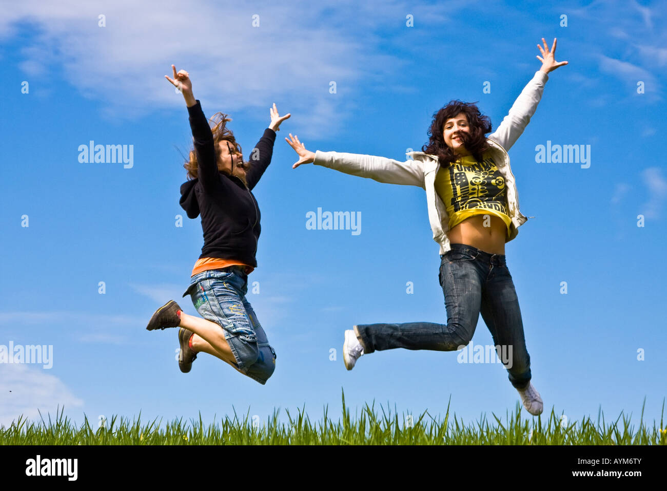 Junge Freunde springen auf der grünen Wiese Stockfoto