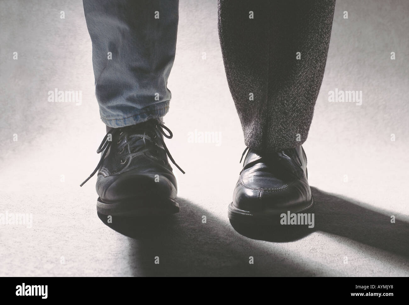 ein Casual und einem elegant Schuh auf denselben Mann s Füße Stockfoto