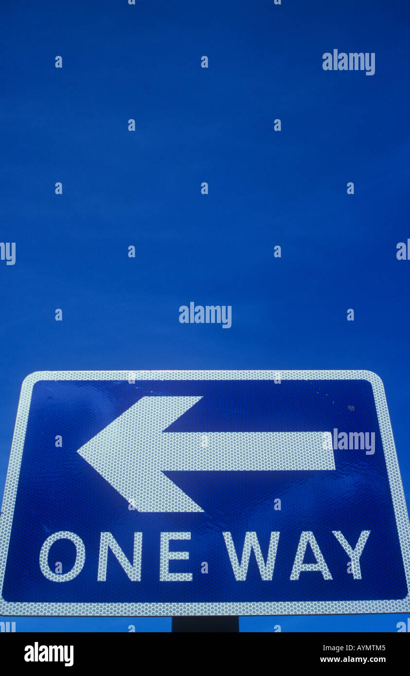 Nahaufnahme von blauen und weißen Roadsign unter blauem Himmel trübe mit Pfeil nach links zeigt und erklärt eine Möglichkeit Stockfoto