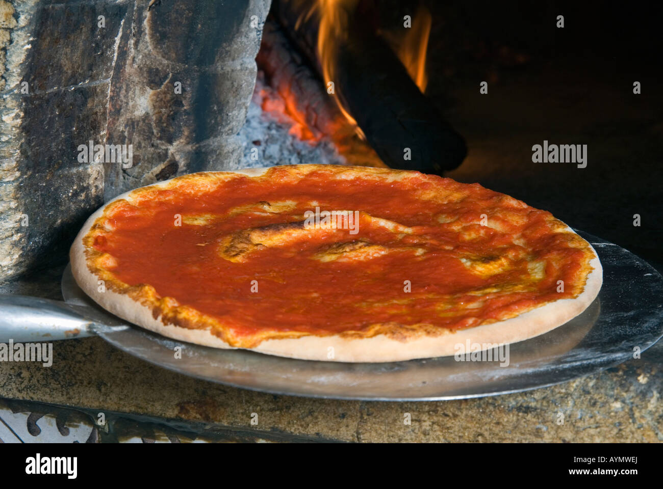 Ziehen Tomaten Pizza aus dem Ofen Stockfoto