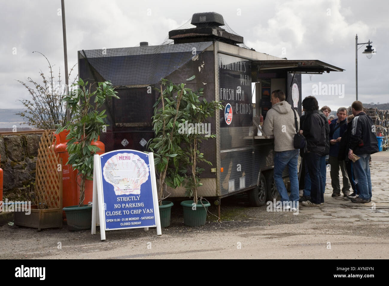 Scottish Chippy Queue. Menschen am mobilen Kiosk Fish & Chips van; Queues Fishermans Pier, Lebensmittel im Verkauf in Tobermory, Balamory Isle of Mull Scotland UK Stockfoto