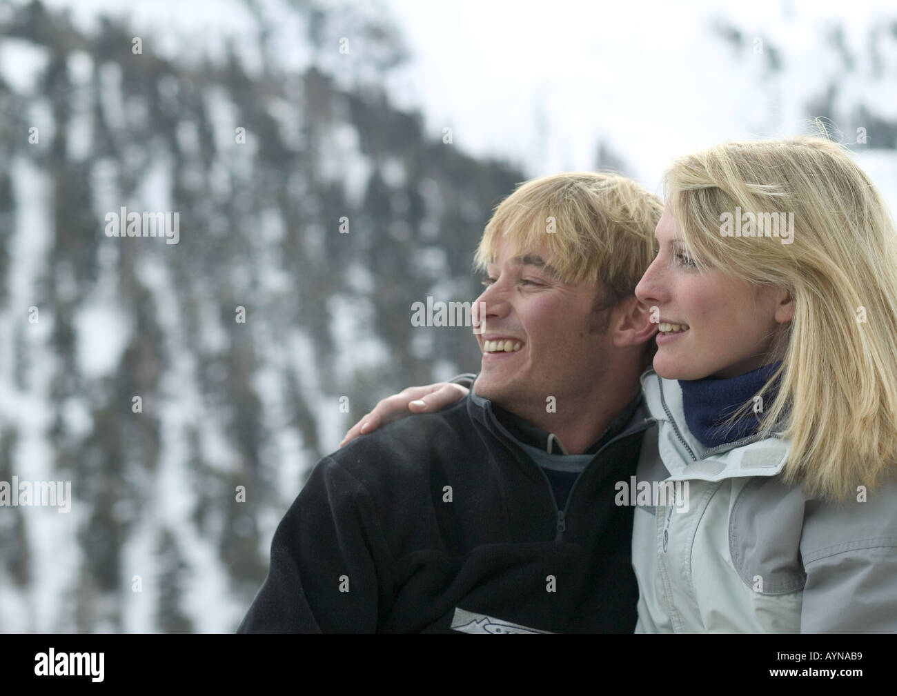 junges Paar entspannt und lächelnd auf Skipisten wegschauen Stockfoto