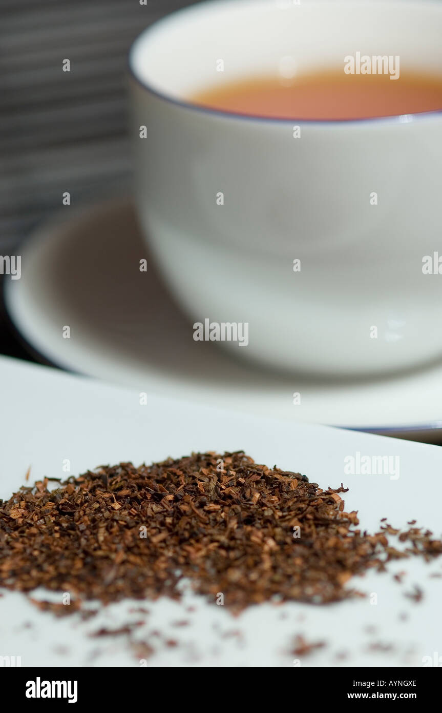 Nahaufnahme von Redbusch Teeblättern und einer Tasse Tee Stockfoto