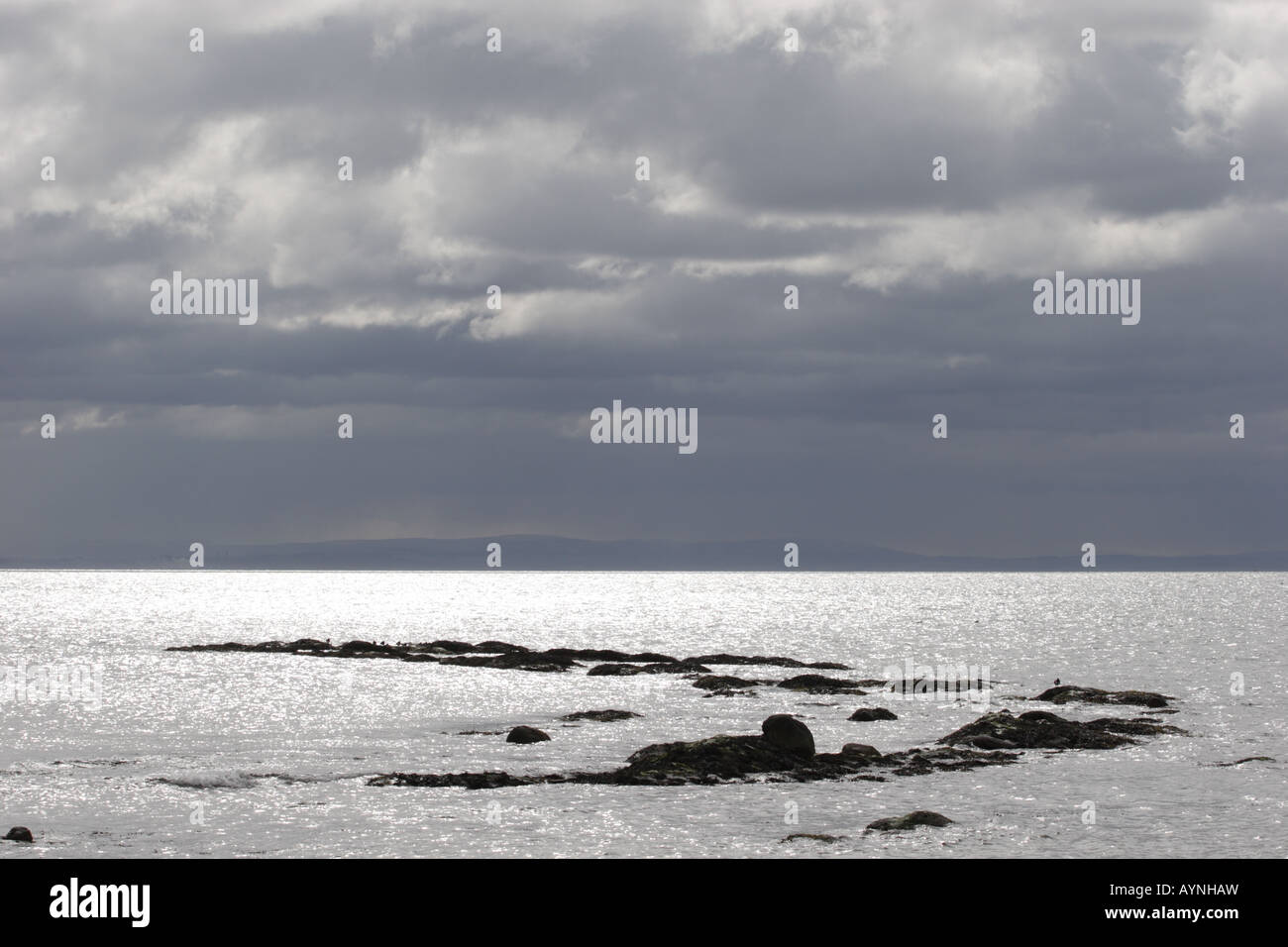 Sonnenlicht bricht durch Winter Sturm Wolken auf den Gewässern des Firth Of Forth glitzerte. Stockfoto