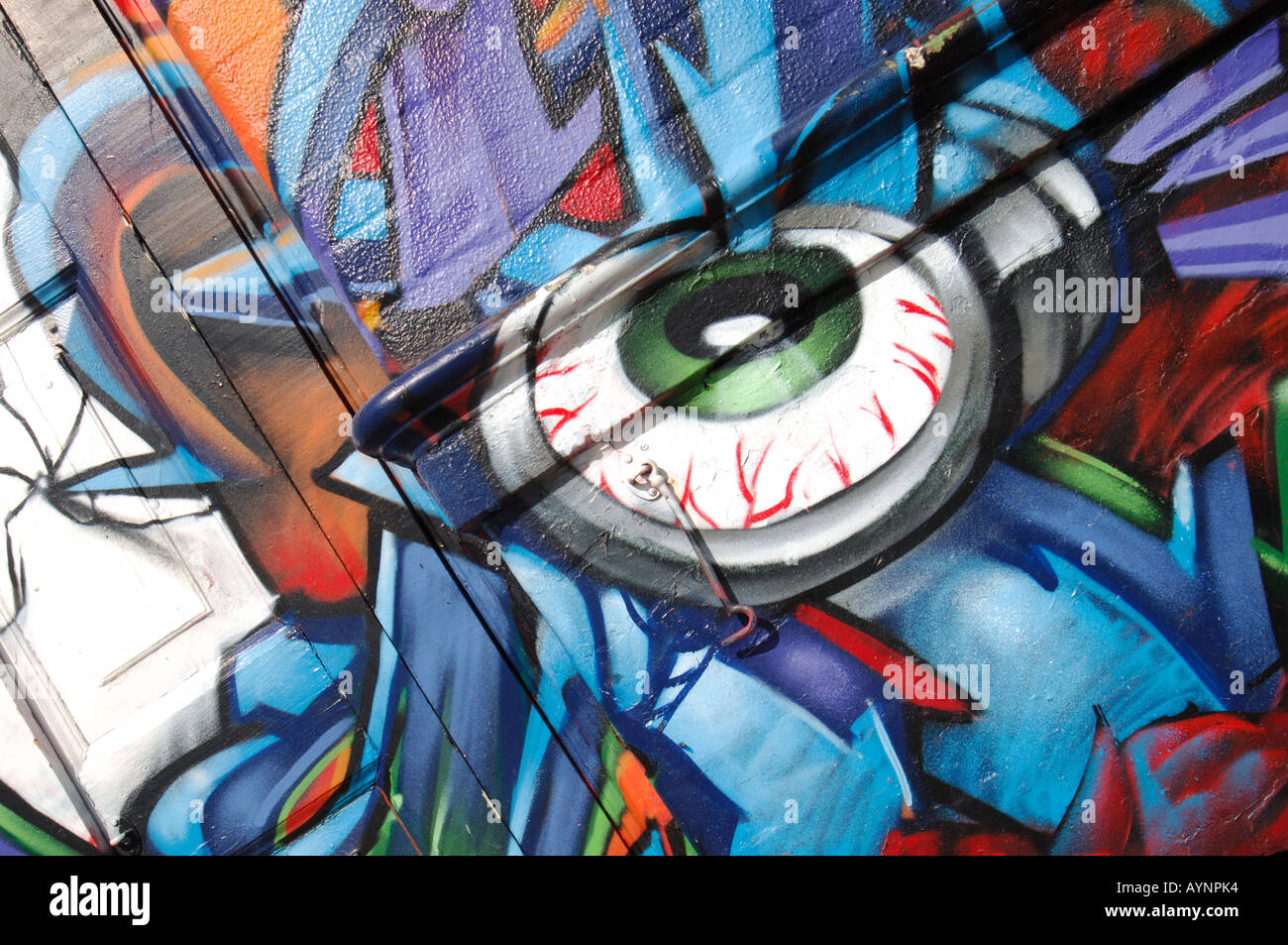 Nahaufnahme von einem Graffiti-Auge umgeben von Buchstaben in blau, lila, Orange, rot auf ein altes Pub in Hepscott Rd. Stockfoto
