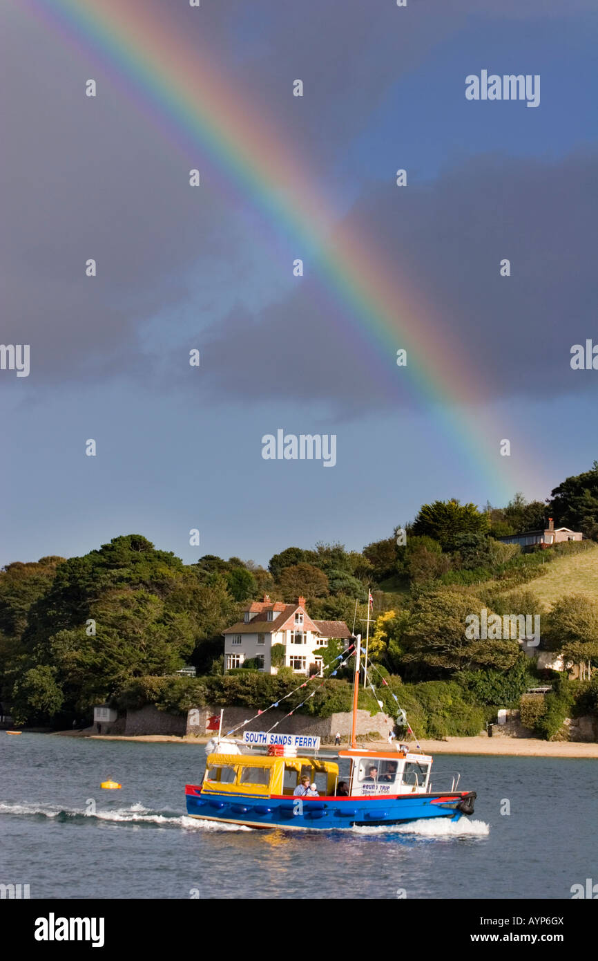 Regenbogen über dem Hafen von Salcombe mit Fähre im Vordergrund, England. Stockfoto