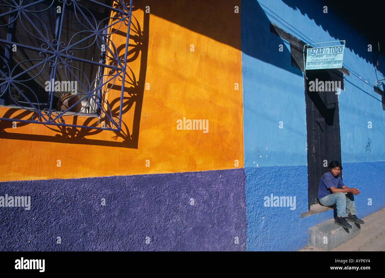 Mexiko Mittelamerika Chiapas San Cristobal de Las Casas Architektur Junge sitzt in Tür bunt gestrichenen Häusern Stockfoto