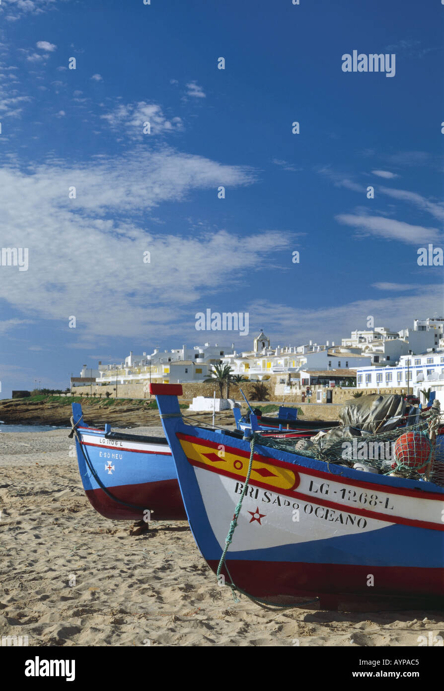 Portugal Algarve Praia da Luz Angeln Boote am Strand, Dorf im Hintergrund Stockfoto