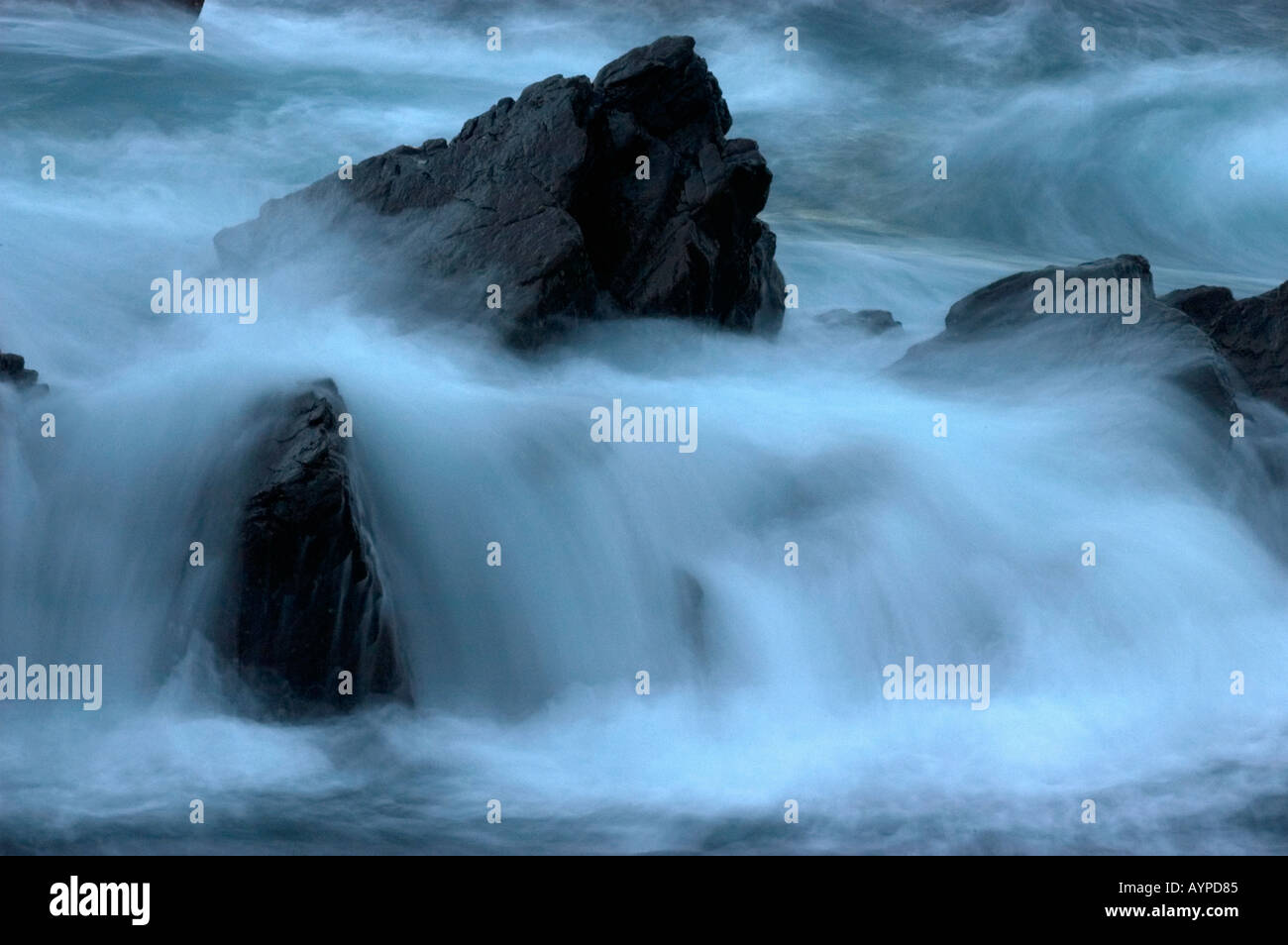 SHETLAND-INSELN. VEREINIGTES KÖNIGREICH. Surfen Sie auf Felsen bei Dämmerung, Schottland Slow motion Stockfoto