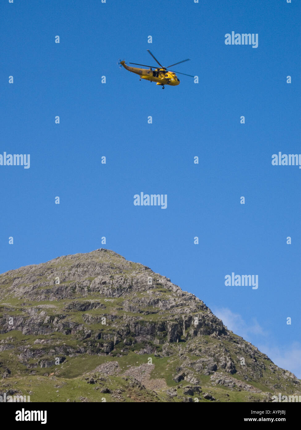 Gelbe Luft Meer Rettungshubschrauber schwebt über Old Man of Coniston, Lake District, Cumbria, UK Stockfoto