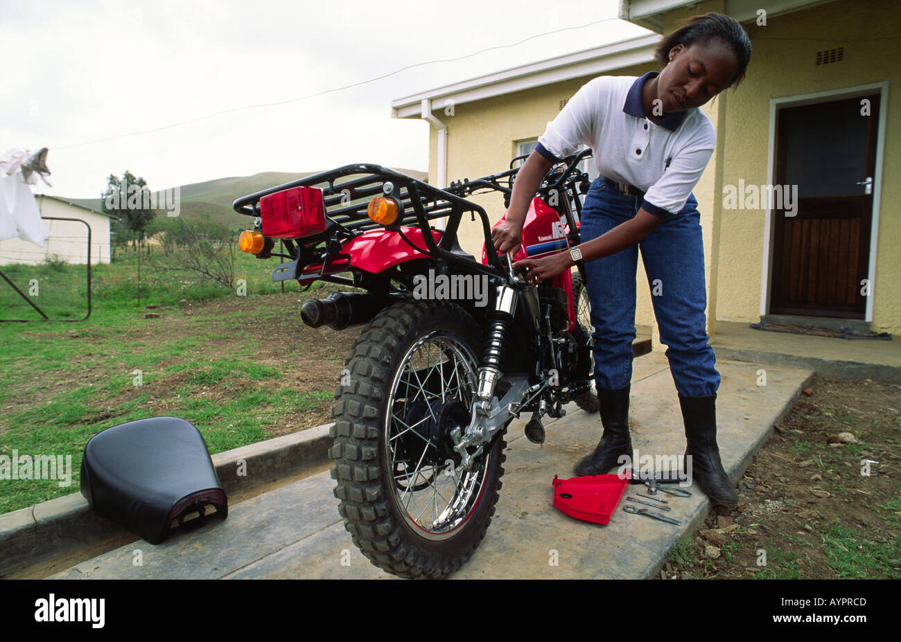 Ausgebildete Gesundheitsbesucherin, auf dem Riders for Health Programm, Wartung auf ihrem Motorrad. Lesotho Stockfoto