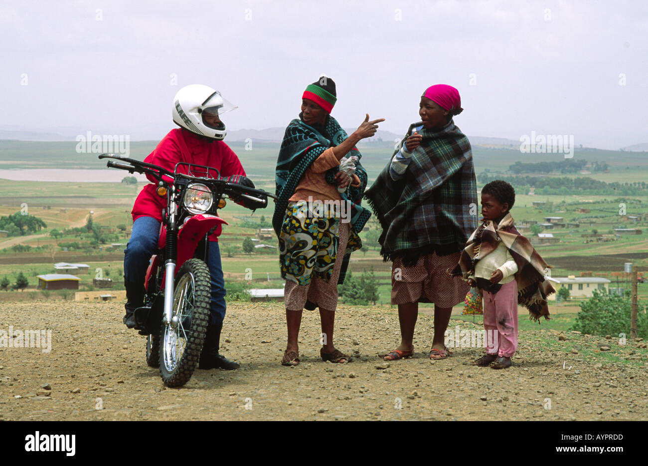 Trainierte Gesundheitsbesucherin auf dem „Riders for Health“-Programm, auf ihrem Motorrad und bat um eine Wegbeschreibung im ländlichen Lesotho Stockfoto