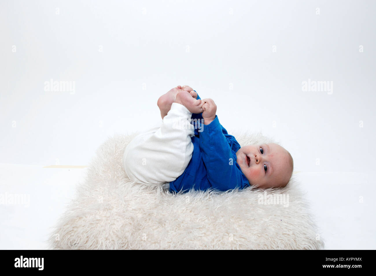 Vier Monate altes Baby junge packte seine Füße Stockfoto