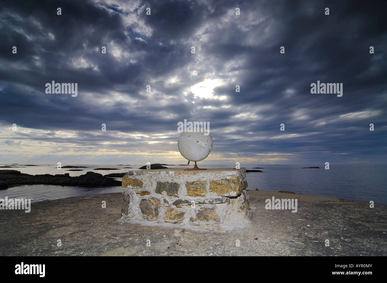 Unbekannte Skulptur, dramatische grauen bewölktem Himmel, konkrete Globus auf einem steinernen Sockel, Nord-Norwegen, Scandinavia Stockfoto