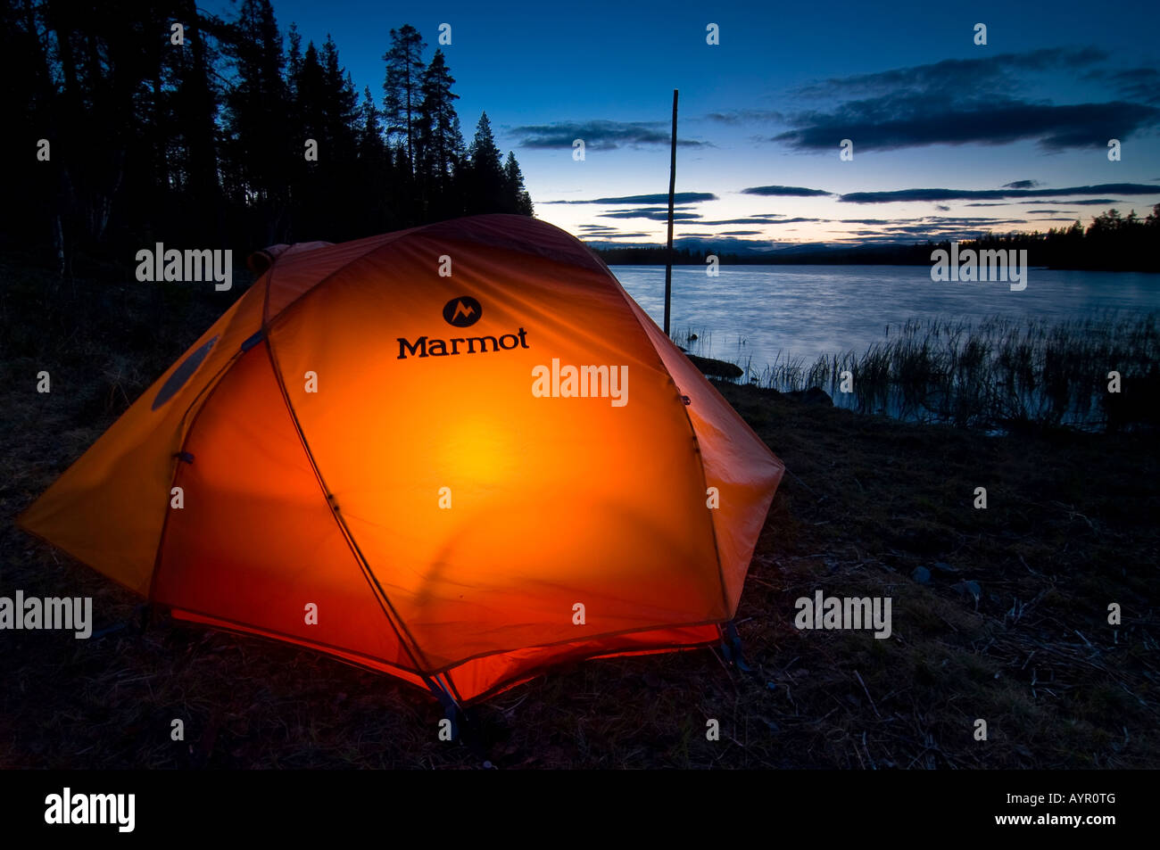 Zelt von innen beleuchtet, in der Dämmerung auf einem See, Femundsmark, Norwegen Stockfoto