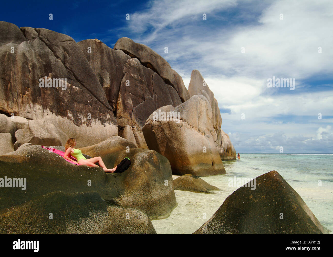 Frau, die Verlegung auf Felsen, Anse Source S'Argent Strand, La Digue Island, Seychellen, Afrika Stockfoto