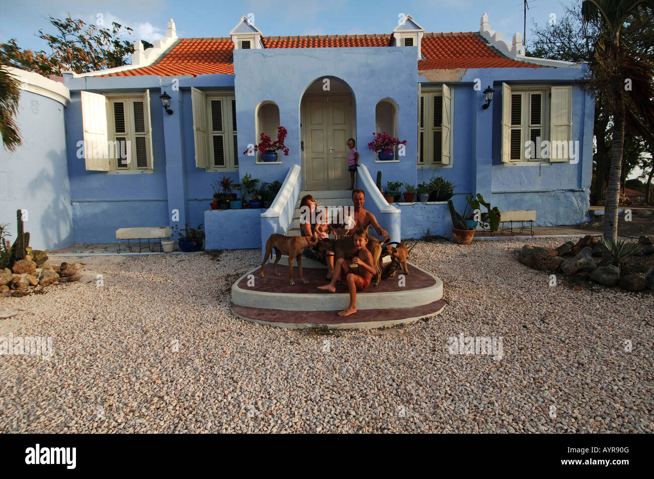 Niederländische Antillen Curacao Expat Familie posiert auf den Stufen des ihrer historischen kolonialen niederländischen Hütte Stockfoto