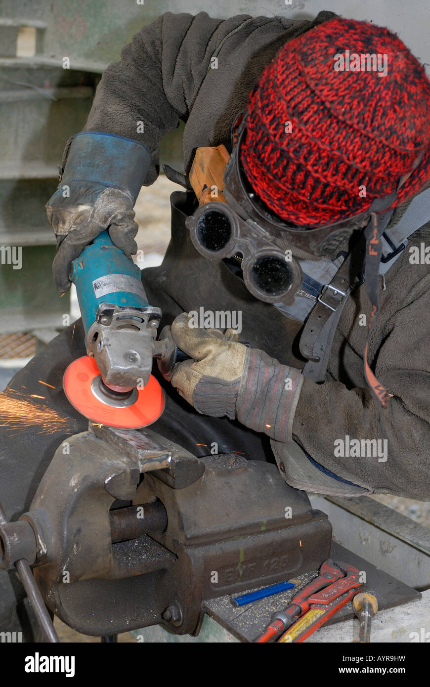 Mann-Metallbearbeitung mit Winkelschleifer Stockfoto