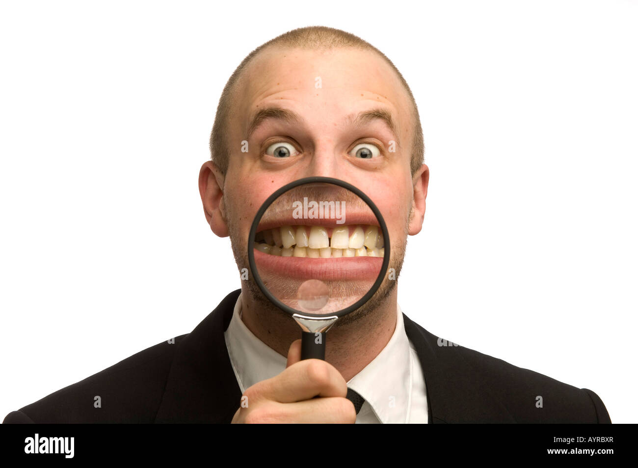 Junger Mann, der Lupe vor den Mund hält Stockfoto