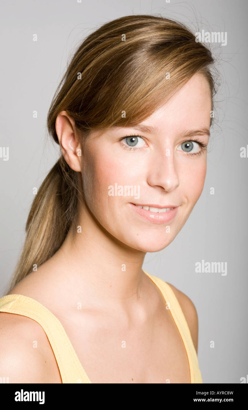 Porträt einer lächelnden jungen Frau trägt einen gelben Tank-top Stockfoto