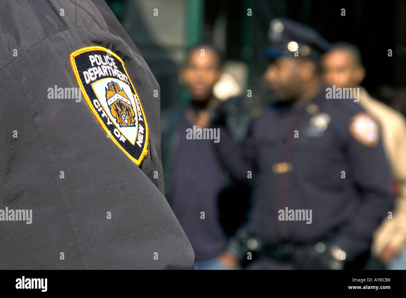 NYPD ABZEICHEN MIT POLIZISTEN IM HINTERGRUND MANHATTAN NEW YORK CITY VEREINIGTE STAATEN VON AMERIKA USA Stockfoto