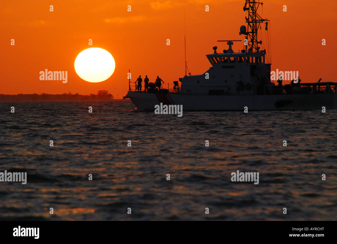 Schiff, das durch einen wunderschönen Sonnenuntergang orange Stockfoto