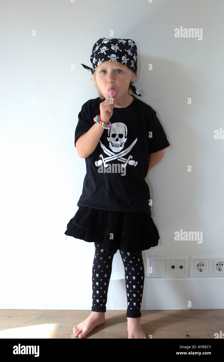 Mädchen mit Piratensymbole von Schädel und gekreuzte Schwerter auf ihr Hemd, ihr Lolly lecken Stockfoto Mädchen mit Piratensymbole von Schädel und gekreuzte Schwerter auf ihr Hemd, ihr Lolly lecken Stockfoto