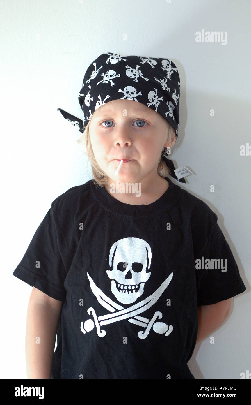 Mädchen mit Piratensymbole von Schädel und gekreuzte Schwerter auf ihr Hemd saugen ihr lolly Stockfoto Mädchen mit Piratensymbole von Schädel und gekreuzte Schwerter auf ihr Hemd saugen ihr lolly Stockfoto