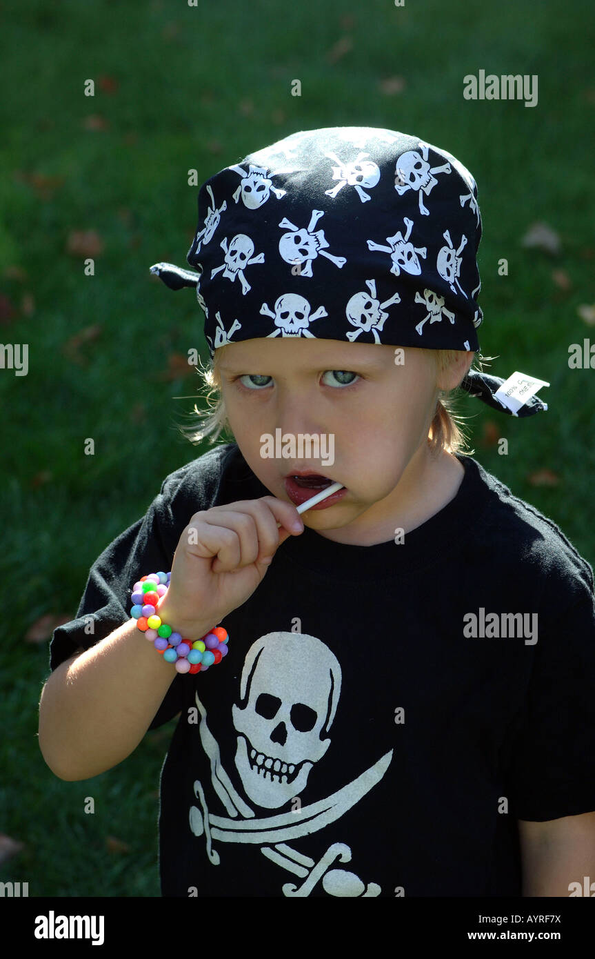 Mädchen mit Piratensymbole von Schädel und gekreuzte Schwerter auf ihr Hemd, ihr Lolly lecken Stockfoto Mädchen mit Piratensymbole von Schädel und gekreuzte Schwerter auf ihr Hemd, ihr Lolly lecken Stockfoto