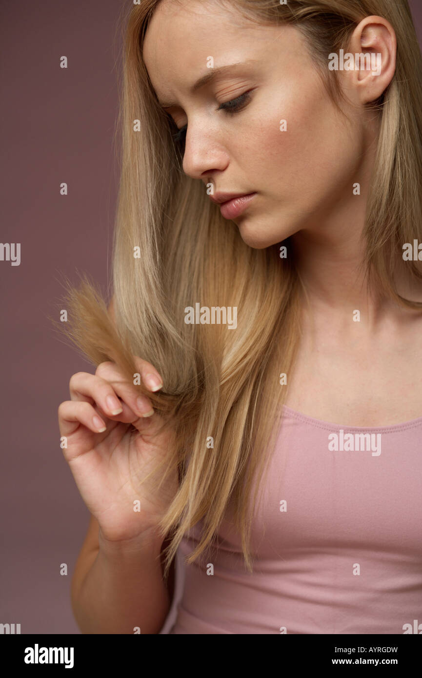 Junge blonde Frau unglücklich über Spliss der blonde lange Haare  Stockfotografie - Alamy