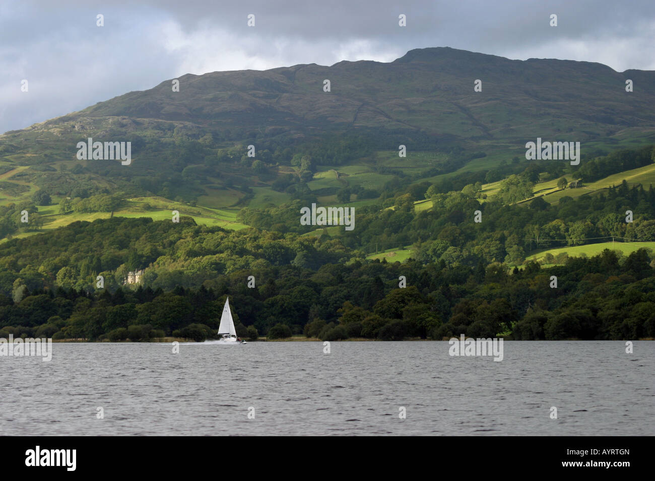 Eine einsame Yacht segelt am Lake Windermere, The Lake District, Cumbria, England Stockfoto