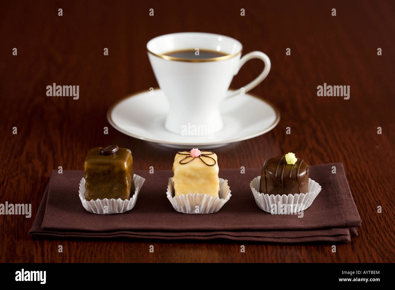 Eine Tasse Kaffee und drei Schokolade Kuchen Stockfoto