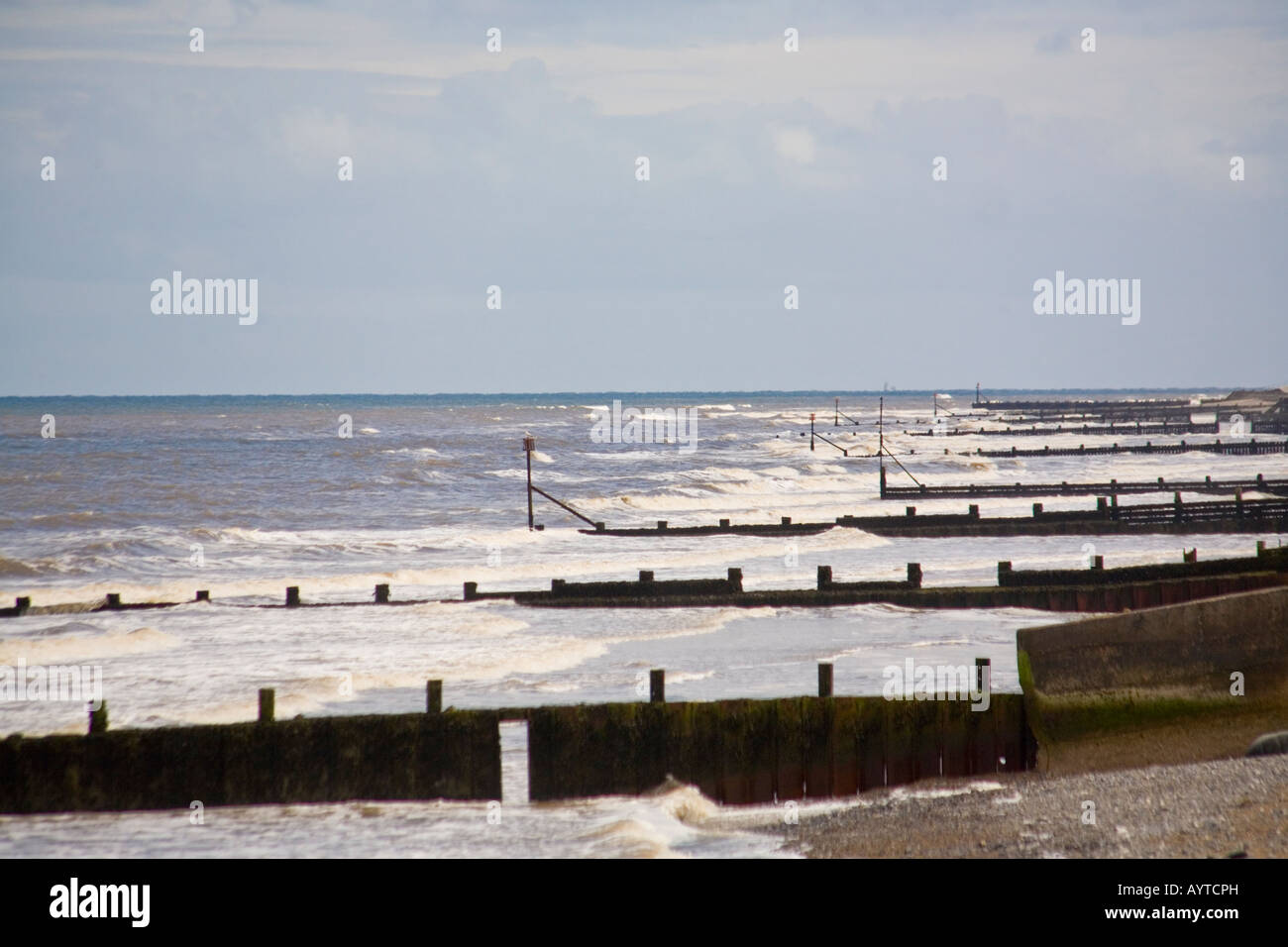 Strand und Meer an der Cromer Norfolk in England mit Wellenbrecher Küstenschutzes und hellem Sommerhimmel Stockfoto