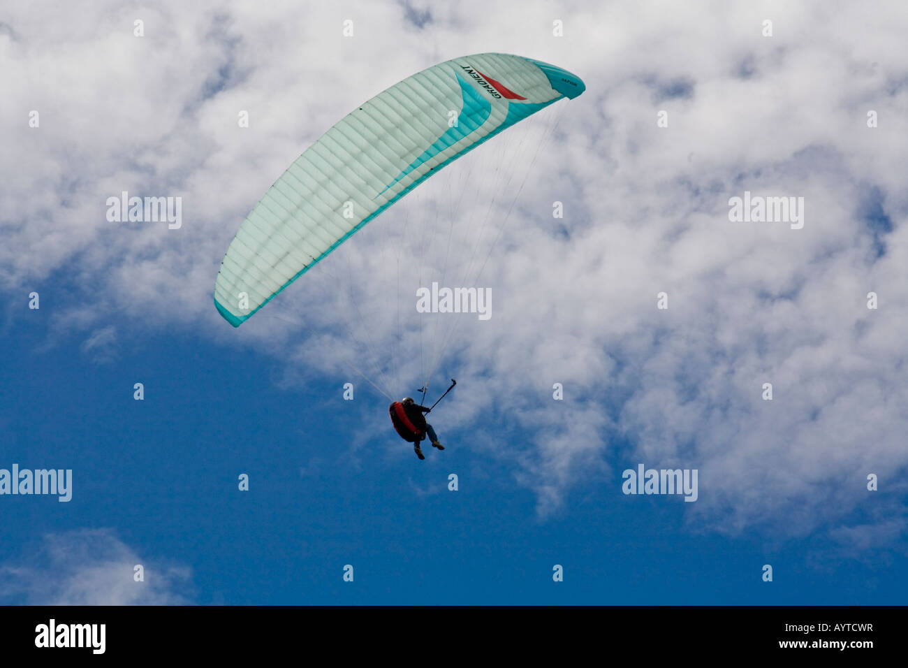 Hängegleiter und Pilot gegen einen hellen blauen und bewölkten Himmel in Norfolk, England Stockfoto